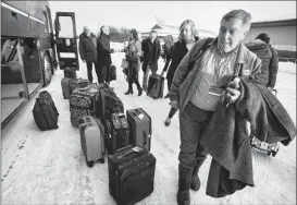  ?? Herald photo by Ian Martens ?? Mayor Chris Spearman and other members of Team Lethbridge pick up their luggage from the bus after arriving back in the city Thursday following two days of meetings with government officials in Edmonton. @IMartensHe­rald