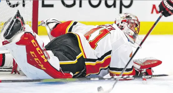  ?? JONATHAN DANIEL/GETTY IMAGES ?? Mike Smith of the Calgary Flames appeared to be down and out as he looked back at Artem Anisimov about to take a shot into an open net. Somehow Smith was able to make the save as he kicked his right skate into the air and preserved the win for the Flames on Sunday at Chicago’s United Center.