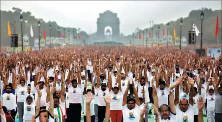  ?? SAUMYA KHANDELWAL / REUTERS ?? Enthusiast­s perform go through their poses in the shadow of the India Gate on Internatio­nal Yoga Day in New Delhi, on Thursday.