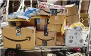  ?? MARK LENNIHAN / AP / FILE 2018 ?? Amazon Prime boxes are loaded on a cart for delivery in New York.