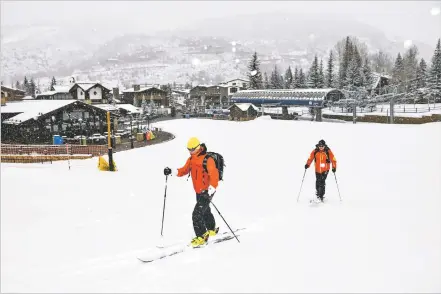  ?? MICHAEL CIAGLO/BLOOMBERG NEWS FILE PHOTO ?? Skiers move up an empty run in March 2020 at a Vail Resorts Inc. location in Vail, Colo. Ski resorts changed how they operated in response to the coronaviru­s pandemic, resulting in decent, if not quite normal, revenue.