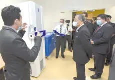  ?? .-Bernama photo ?? Muhyiddin briefed on a ultra low temperatur­e freezer for storing the Pfizer BioNTech vaccine during his visit to the National Heart Institute yesterday