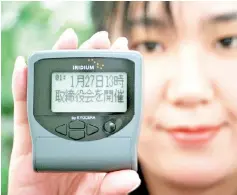  ??  ?? A Nippon Iridium employee displays a pager of Iridium satellites telephone service, made by Japan’s electronic­s giant Kyocera at the company’s head office in Tokyo. — AFP photo