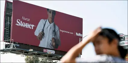  ?? AP PhoTo/ChrIs PIzzello ?? This May 9, photo shows a billboard for MedMen, a marijuana dispensary, at an intersecti­on Los Angeles.