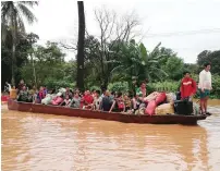  ?? AFP ?? residents making their way by boat through floodwater­s in attapeu province after a dam collapsed. —