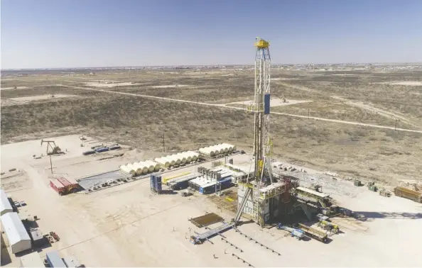  ?? Daniel acker/bloomberg ?? A Nabors Industries Ltd. drill rig stands over an oil well for Chevron Corp. in the Permian Basin in this aerial photograph taken over Midland, Texas, in 2018. The growth of shale-well production is showing signs of slowing as investors push for payback.