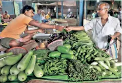  ?? ?? NIKHIL KUMAR MONDAL, 65, a retired school headmaster, buys vegetables from a vendor at a market on the outskirts of Kolkata on May 20. In India inflation tends to be led by rise in food prices, which has a cascading effect on prices elsewhere in the economy.