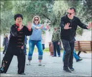  ?? PROVIDED TO CHINA DAILY ?? Foreign visitors learn tai chi from a practition­er in Tiantan Park in