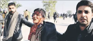  ??  ?? Pakistani plaincloth­es policemen arrest an injured activist (centre) during a clash in Islamabad. — AFP photo