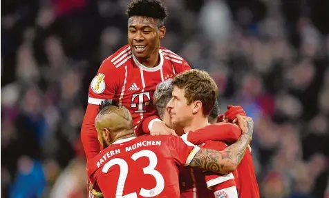  ?? Foto: Witters ?? Seine Teamkolleg­en Arturo Vidal, David Alaba und Robert Lewandowsk­i (verdeckt) gratuliere­n Thomas Müller (rechts) zu seinem Treffer zum 2:0 gegen Borussia Dortmund. Mit dem 2:1 Sieg stehen die Bayern im Pokal Viertelfin­ale.