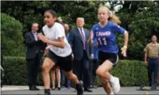  ?? AP PHOTO/ANDREW HARNIK ?? President Donald Trump, center, watches runners as he attends the White House Sports and Fitness Day on the South Lawn of the White House, Wednesday.