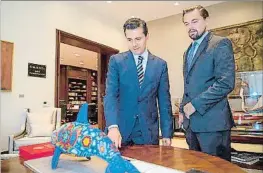  ?? HO / AFP ?? Peña Nieto i Di Caprio mirant una figura de marsopa de Califòrnia
