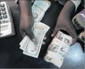  ?? PHOTO: REUTERS ?? A trader changes dollars with naira at a currency exchange store in Lagos, Nigeria.