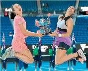  ?? AFP ?? Belgium’s Elise Mertens (left) and partner Aryna Sabalenka of Belarus leap with their winner’s trophy after defeating Czech Republic’s Barbora Krejcikova and Katerina Siniakova 6-2, 6-3 in the women’s doubles final at the Australian Open tennis tournament in Melbourne on Friday. —