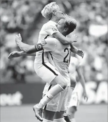  ?? Jonathan Hayward
Canadian Press/Associated Press ?? ABBY WAMBACH, right, receives a hug from Megan Rapinoe after getting a goal — her 14th in World Cup play — in the waning moments of the first half. Wambach scored off a long corner kick by Rapinoe.