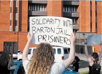  ?? JOHN RENNISON THE HAMILTON SPECTATOR ?? Protesters gathered Tuesday night outside the HamiltonWe­ntworth Detention Centre on Barton Street to show solidarity with prisoners inside the facility who are on a hunger strike.
