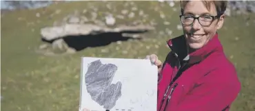  ??  ?? 0 Dr Tertia Barnett, of HES, holding a graphic showing prehistori­c carvings found at Kilmartin Glen