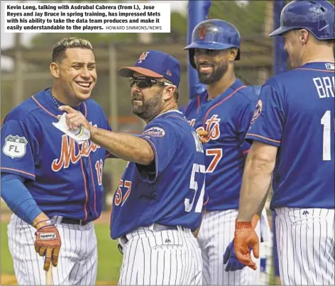  ??  ?? Kevin Long, talking with Asdrubal Cabrera (from l.), Jose Reyes and Jay Bruce in spring training, has impressed Mets with his ability to take the data team produces and make it easily understand­able to the players.