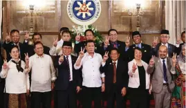  ?? CZAR DANCEL ?? PARA SA KAPAYAPAAN Nag-peace sign si Pangulong Rodrigo Duterte (gitna) sa pagpapakuh­a ng litrato kasama ang peace panel, sa turnover ceremony ng Bangsamoro Basic Law (BBL) draft sa Malacañang kamakalawa.