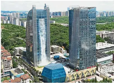  ?? — AFP ?? Costly cascade: The 108m-high waterfall with about RM476 an hour pouring down the facade of the Liebian Internatio­nal Building in Guiyang.