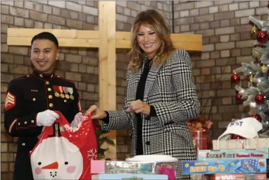  ?? ALASTAIR GRANT ?? FILE - In this Dec. 4, 2019, file photo first lady Melania Trump joins local students and U.S. Marines stationed at the U.S. Embassy, wrapping holiday presents to be donated to the Salvation Army, at the Salvation Army Clapton Center in London. Melania Trump is quietly forging her way through President Donald Trump’s impeachmen­t.