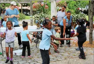  ?? MICHILEA PATTERSON — DIGITAL FIRST MEDIA ?? Children have fun with bubbles at the Smith Family Plaza on Thursday. Several family friendly activities were available at the plaza as part of the “Almost Friday” event of the weekly outdoor farmers market in Pottstown.