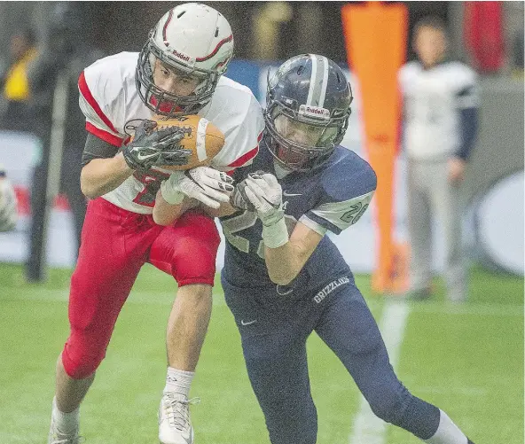  ?? ARLEN REDEKOP/PNG FILES ?? James Gemmell of the Carson Graham Eagles makes a game-saving intercepti­on in front of Ethan Mastin of the GW Graham Grizzlies in last season’s Subway Bowl. This season, Gemmell is considered a team leader and ‘coach on the field’ for the Eagles.