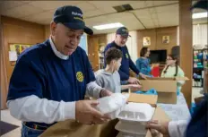  ?? ?? Herman Dieckmann, a member of the Rotary Club of BethelSt. Clair, helps pack Thanksgivi­ng meals on Thursday as part of the “Get Stuffed with Love” meal distributi­on event held at Mary’s Holy Assumption Orthodox Church on the South Side.
