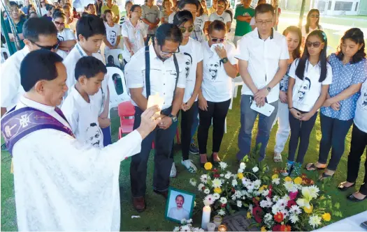  ?? (SUN.STAR FOTO/RUEL ROSELLO) ?? REMEMBERIN­G.
The immediate family of slain lawyer Noel Archival gathered yesterday on his death anniversar­y at the Angelicum Cemetery.