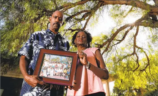  ?? Photograph­s by Robert Gauthier Los Angeles Times ?? EDWARD AND BEA STRICKLAN are the parents of a man with serious mental illness who is incarcerat­ed in L.A. County’s Twin Towers jail. They hold a photo from an event, sponsored by the National Alliance on Mental Illness, showing them with their son and numerous friends who were there to support them.