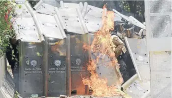  ?? FOTO: AFP ?? Una bomba molotov explota contra los escudos de la policía venezolana antidistur­bios en el centro de Caracas, durante la jornada de ayer.