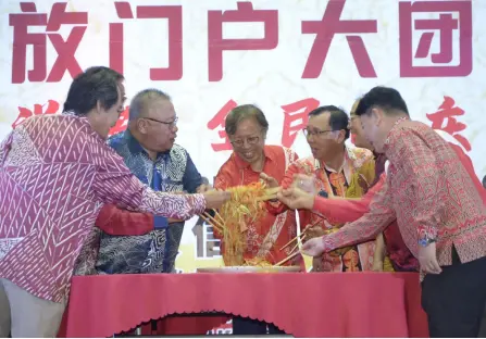  ?? ?? Abang Johari (centre), flanked by Tiong on his right and Dr Rundi, joins other guests in tossing the yee sang during the event.