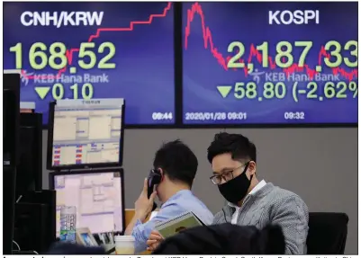  ?? (AP/Ahn Young-Joon) ?? A currency trader wearing a mask watches works Tuesday at KEB Hana Bank in Seoul, South Korea. Businesses with ties to China are monitoring the coronaviru­s outbreak there.