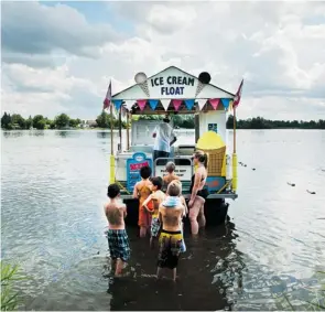  ?? BRUCE DEACHMAN/OTTAWA CITIZEN ?? Day-campers line up for ice cream at Bob Harlow’s Ice Cream Float boat at Baxter Beach on the Rideau River. Harlow has been running his summer business since 2000.