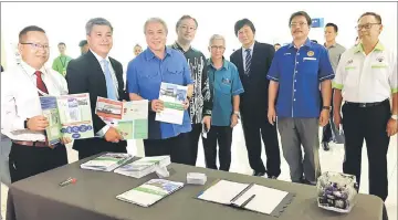  ??  ?? Awang Tengah (third left), Assistant Minister of Industries and Investment Malcolm Mussen Lamoh (third right) and others in a photo-call at one of the booths set up for the event.