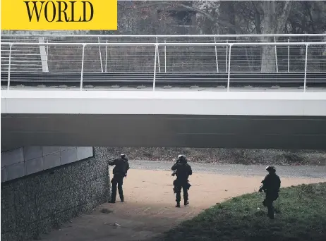  ?? FREDERICK FLORIN / AFP / GETTY IMAGES ?? Members of the French police special forces RAID conduct searches on a bank of the river Rhine in Strasbourg on Wednesday in their hunt for the gunman who opened fire near a Christmas market Tuesday night in Strasbourg, France. Two have died and 13 are injured.