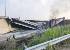  ?? OFFICE OF EMERGENCY MANAGEMENT VIA AP ?? Firefighte­rs stand Sunday near the collapsed part of Interstate 95 in Philadelph­ia. The elevated section of I-95 collapsed after a vehicle caught fire beneath it.