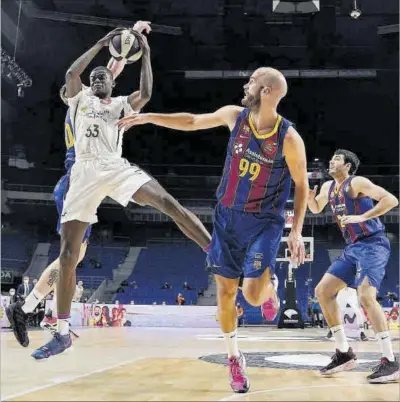  ?? JUAN CARLOS HIDALGO / EFE ?? El jugador de l’Unicaja Nzosa captura un rebot en presència del blaugrana Calathes.