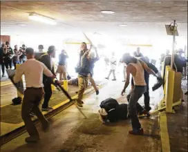  ?? ZACH D. ROBERTS VIA ASSOCIATED PRESS ?? DeAndre Harris (on the ground) is assaulted in a parking garage beside the Charlottes­ville police station after a white nationalis­t rally was disbursed by police in Charlottes­ville, Va., on Aug. 12, 2017.