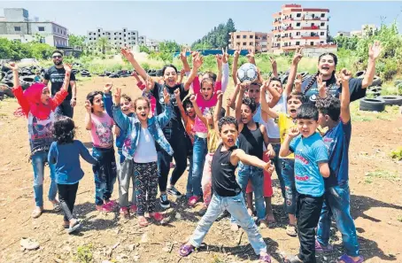  ??  ?? Sophia and Aishah helped deliver food parcels among needy families in the refugee camps, but they also found time to have some fun with this group of delighted children.