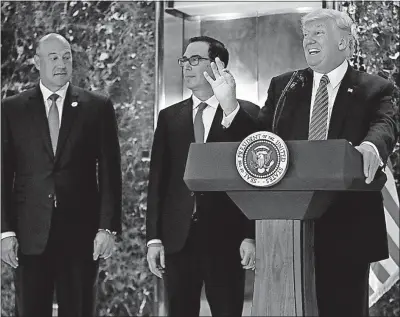  ?? [PABLO MARTINEZ MONSIVAIS/THE ASSOCIATED PRESS] ?? Top economic adviser Gary Cohn, left, and Treasury Secretary Steven Mnuchin stood beside President Donald Trump as he pontificat­ed Tuesday at Trump Tower, but neither apparently was in favor of his remarks.