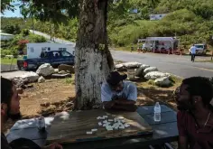  ??  ?? Men play dominoes earlier this month in St. Thomas.