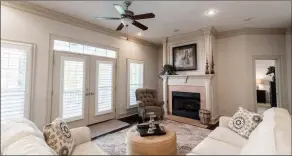  ?? ?? A lovely gas-log fireplace anchors the main living area, and double doors provide access to the back deck.