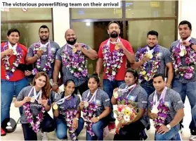  ??  ?? The victorious powerlifti­ng team on their arrival