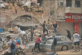  ?? (File Photo/AP/Felipe Dana) ?? People remove debris from a house damaged by an explosion.