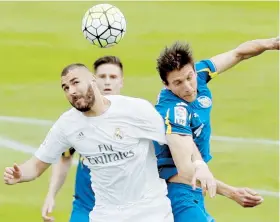  ??  ?? El delantero francés del Real Madrid Karim Benzema (i) disputa un balón con el defensa argentino del Getafe Santiago Vergini (d).