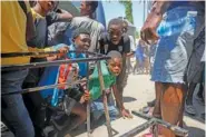  ?? AP PHOTO/ODELYN JOSEPH ?? Youth take cover March 22 after hearing gunshots at a public school in Port-au-Prince, Haiti.