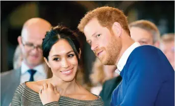  ?? BEN BIRCHALL/AP ?? Britain’s Prince Harry talks to Meghan Markle as they watch a dance performanc­e by Jukebox Collective in the banqueting hall during a visit to Cardiff Castle, Wales. With Prince Harry and Meghan Markle’s May 19 wedding fast approachin­g, the fashion and...