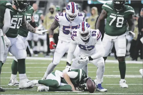  ?? PHOTO/BILL KOSTROUN
AP ?? Buffalo Bills’ A.J. Epenesa (57) and Efa Obada (93) look down at New York Jets quarterbac­k Mike White, bottom, after a sack during the second half of an NFL football game on Sunday in East Rutherford, N.J.