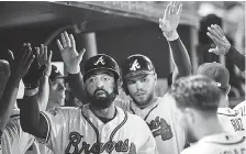  ??  ?? Atlanta players congratula­te Matt Kemp, left, and Freddie Freeman after Kemp’s two-run home run during the fourth inning of Wednesday night’s home game against the Philadelph­ia Phillies.